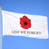 ANZAC memorial flag with red poppy and Lest We Forget text