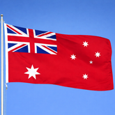 Australian flag with Union Jack in the corner against a clear blue sky