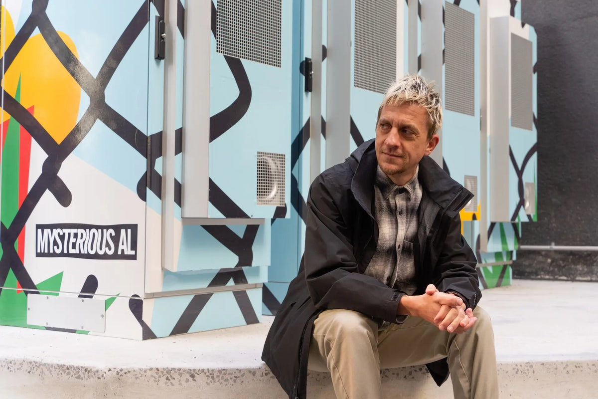 Local artist Mysterious Al with his custom artwork on the Power Melbourne community battery, enhancing the urban environment with vibrant and meaningful designs. Photo credit: City of Melbourne. | Custom signage by Evan Evans Australia