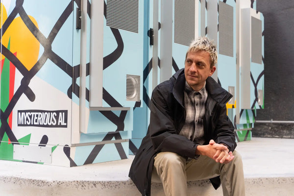 Local artist Mysterious Al with his custom artwork on the Power Melbourne community battery, enhancing the urban environment with vibrant and meaningful designs. Photo credit: City of Melbourne.