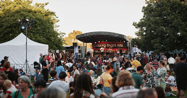 Crowd gathered in front of the Coburg Night Market stage, featuring event branding and live entertainment signage.