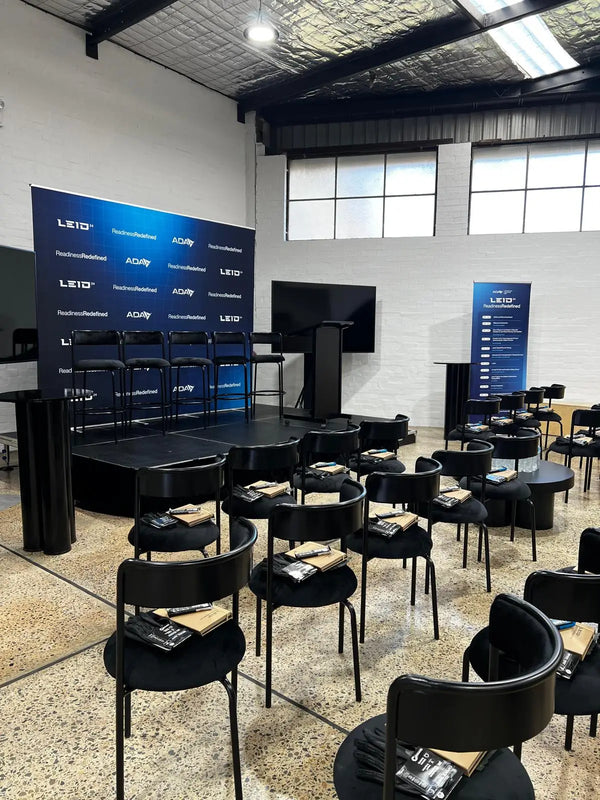 A high-quality media wall and pull-up banner displayed at ADA & LEGEAR's LEID event. The vibrant graphics and professional finish demonstrate the impact of combining these signage solutions for a cohesive look.