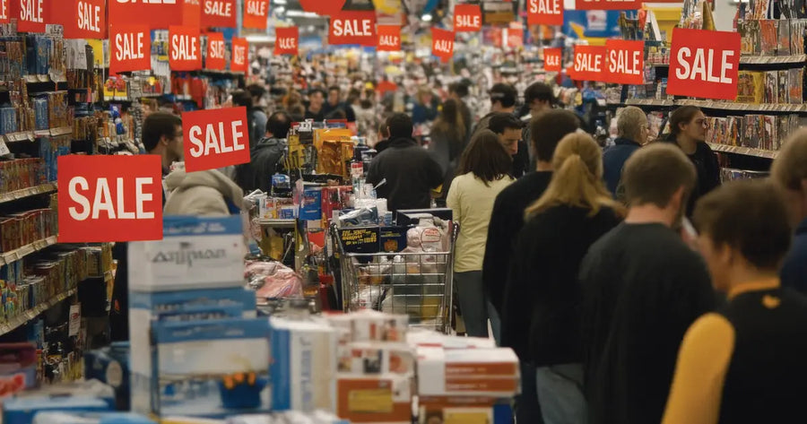 Crowded Australian retail store with bright red sale signage and promotional discount displays
