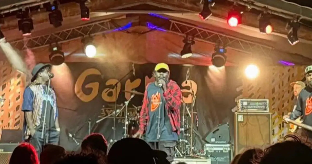 Live music performance on the Garma Festival stage with lighting and crowd atmosphere | Custom signage by Evan Evans Australia