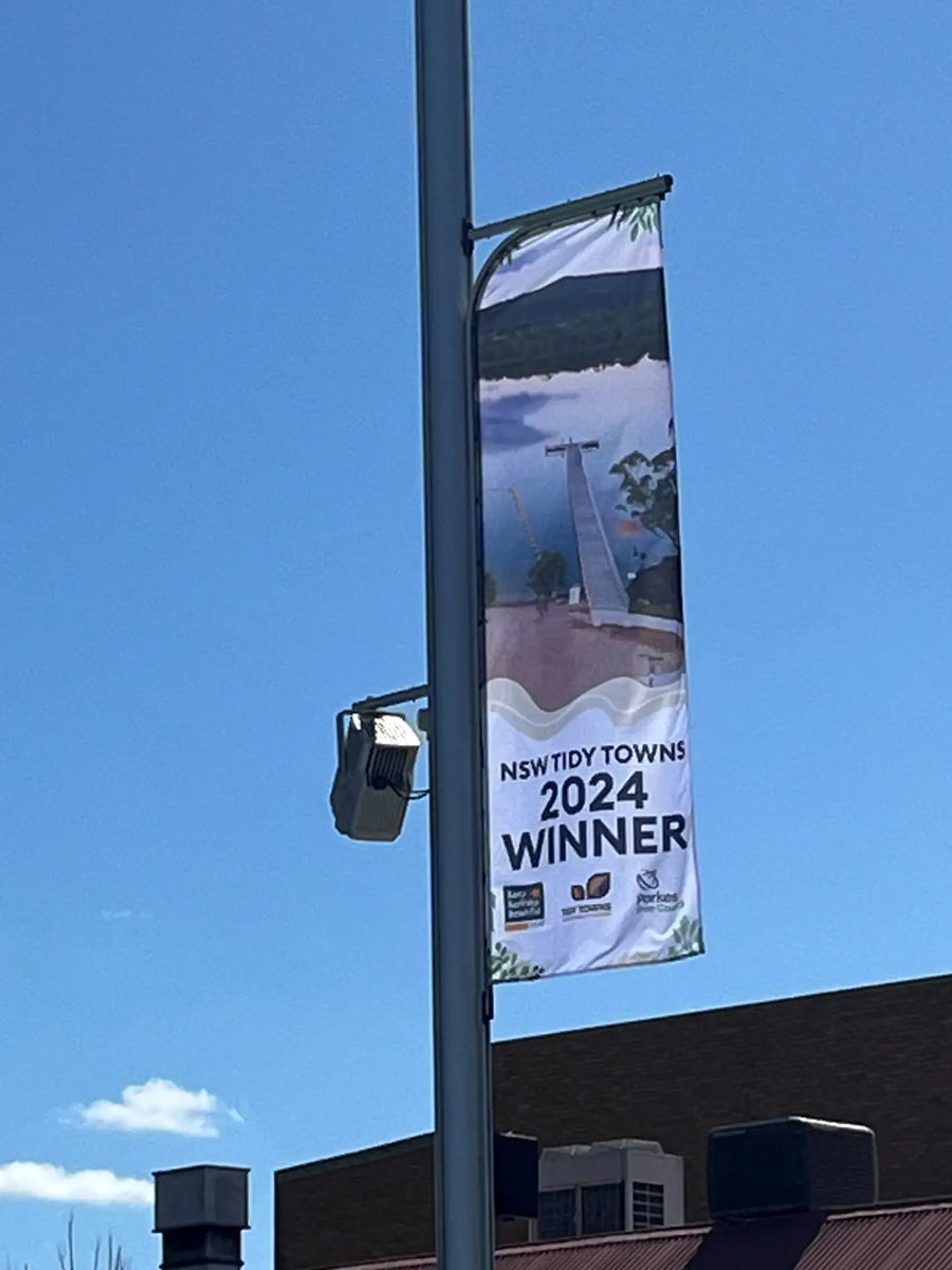 FlagTrax street banner system with custom printed banner installed on a pole by Evan Evans