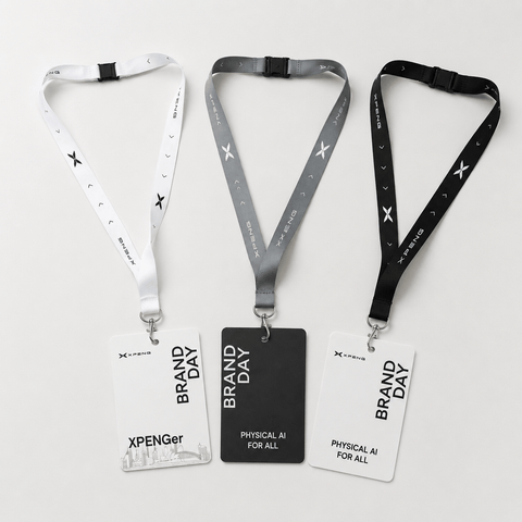 Three lanyard ID badges displayed on a light gray background. The left lanyard is white with black text and star motifs, paired with a white card.