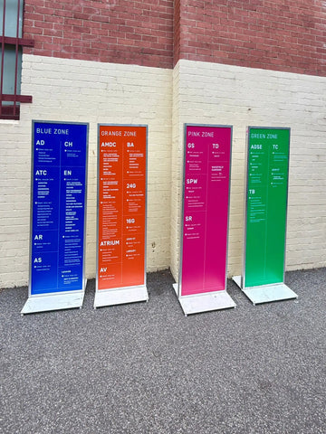 Lineup of orange, pink, blue and green corflute wayfinding signs at Swinburne