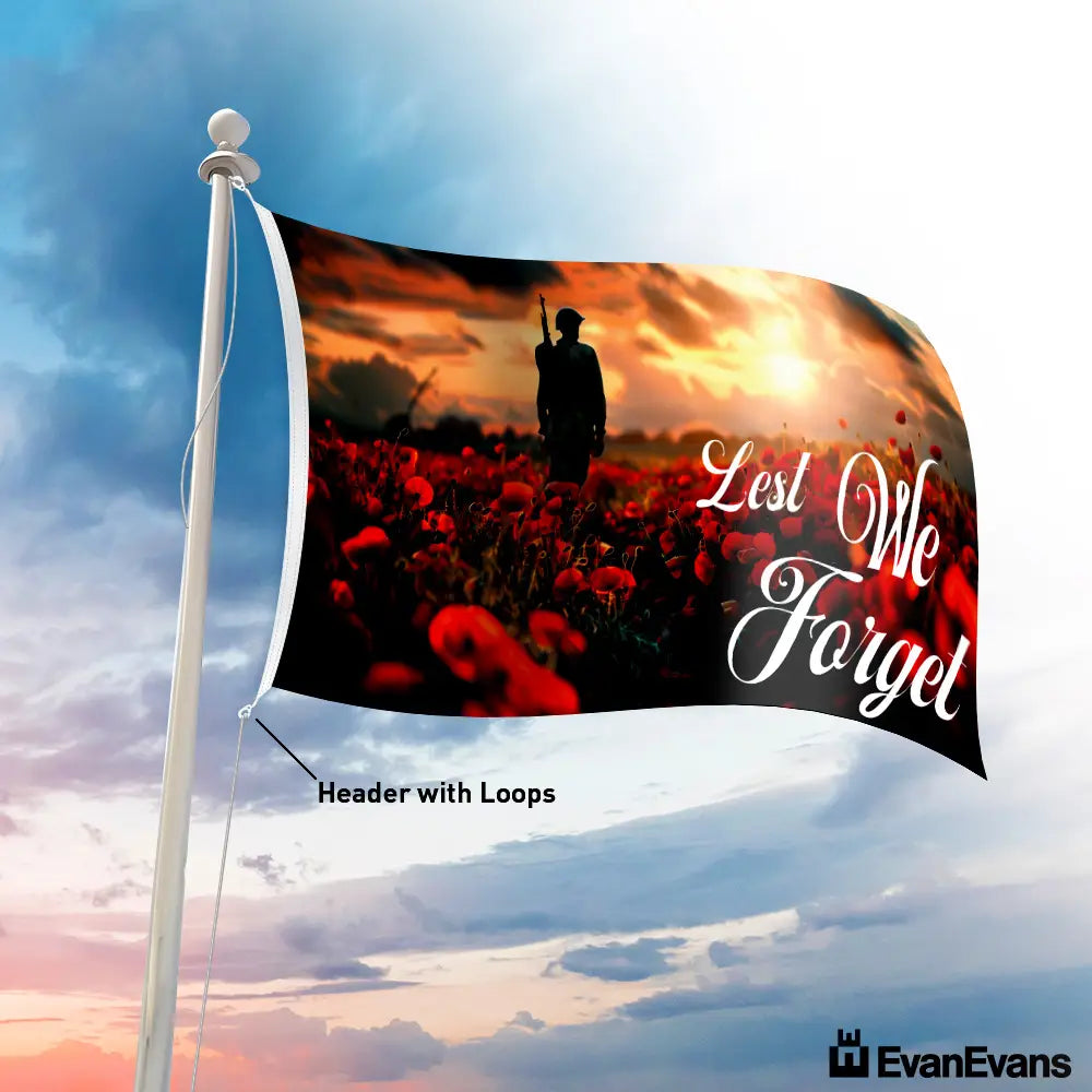 Lest We Forget flag with a soldier standing in a poppy field at sunset, symbolizing remembrance for ANZAC Day and Remembrance Day.