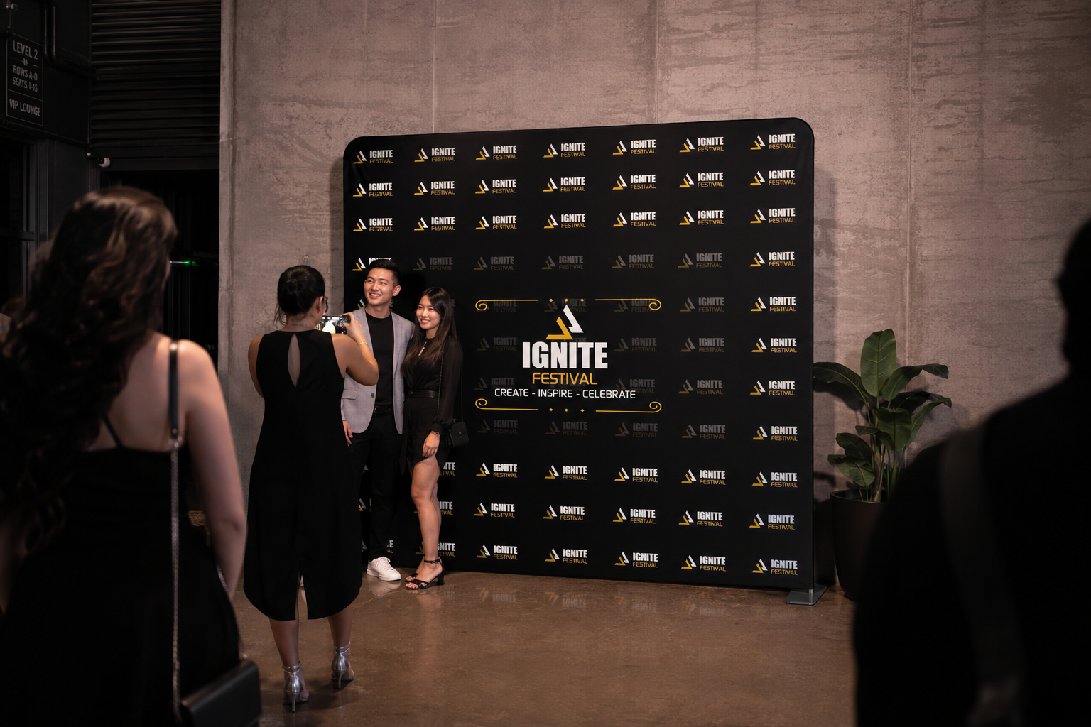 People posing in front of a promotional backdrop for the 'Ignite Festival' event.