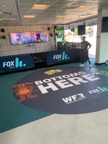 Custom indoor floor graphics at the FOX FM World Famous Rooftop event, featuring playful designs and branding, enhance the atmosphere and create engaging photo opportunities.