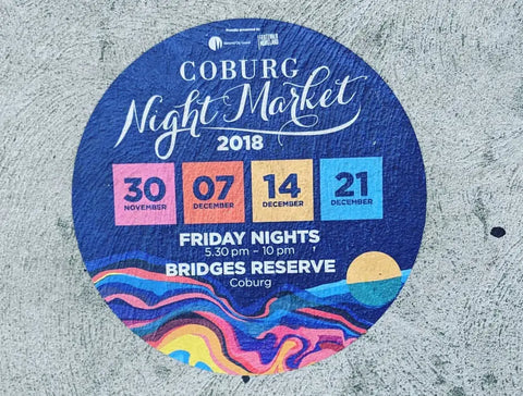 A striking circular floor decal promotes the 2018 Coburg Night Market, showcasing event dates and colorful designs to attract visitors and guide foot traffic.