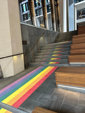 Rainbow graphics adorn the staircase at 447 Collins Street to celebrate Pride Month, creating an inclusive and welcoming visual statement in a public space.